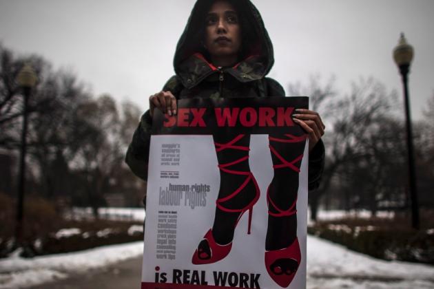 A woman (requested to withhold her name) holds a sign during a rally at Allan Gardens park to support Toronto sex workers and their rights in Toronto, Friday December 20, 2013. (Mark Blinch / THE CANADIAN PRESS)